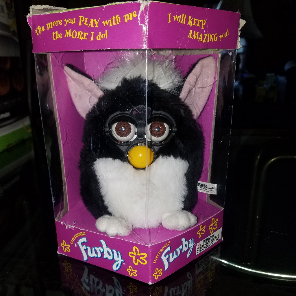 Boxed black and white first-generation 1998 Furby showing the mechanical eyes and beak of the original design